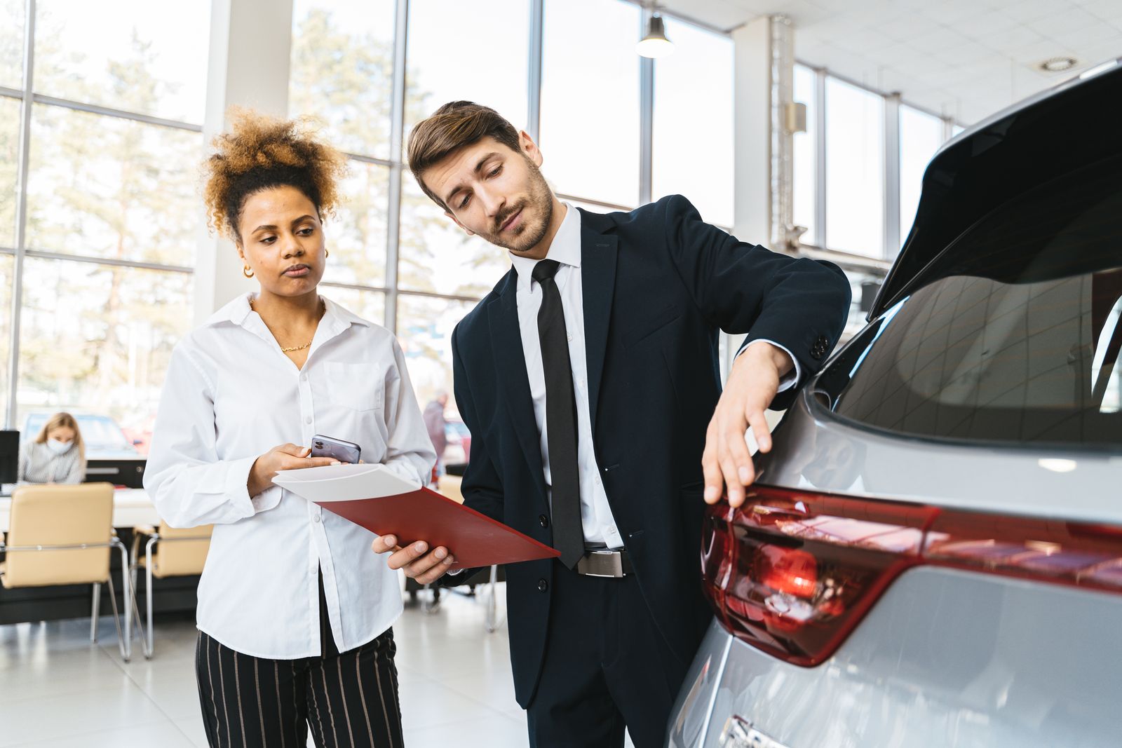 A lease advisor talking a customer through paperwork in the showroom